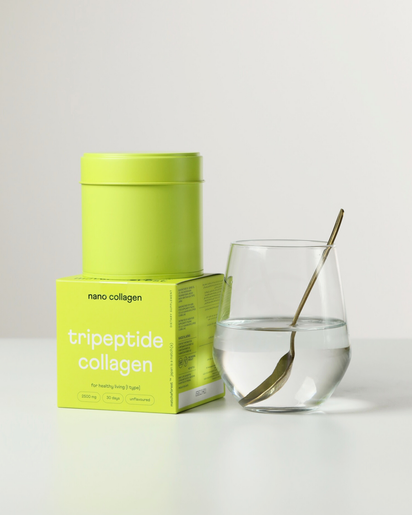 A packaging of marine tripeptide collagen for skin, hair, nails, bones and joints next to a glass of clear water with collagen