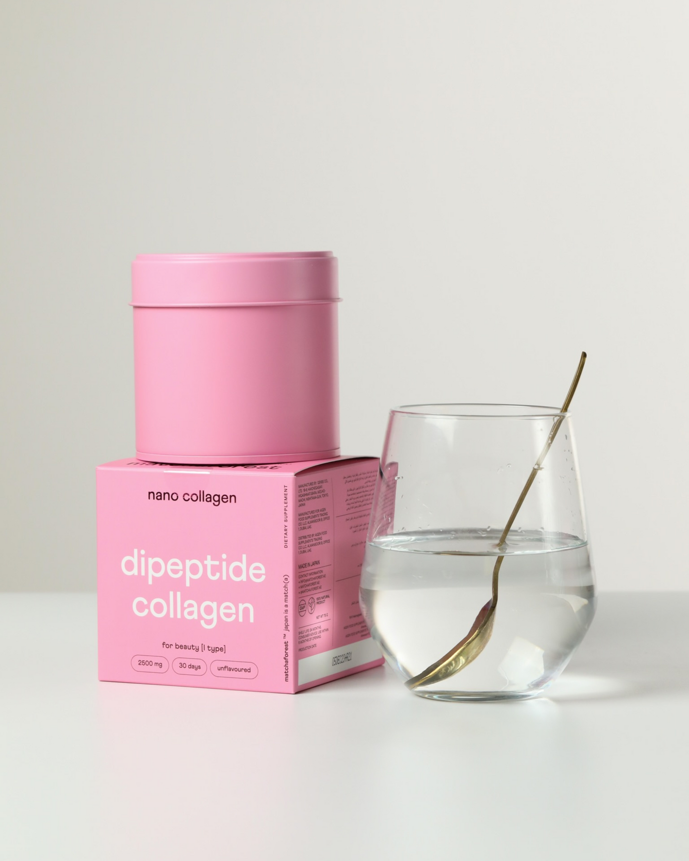 A packaging of marine dipeptide collagen next to a glass of clear water with collagen